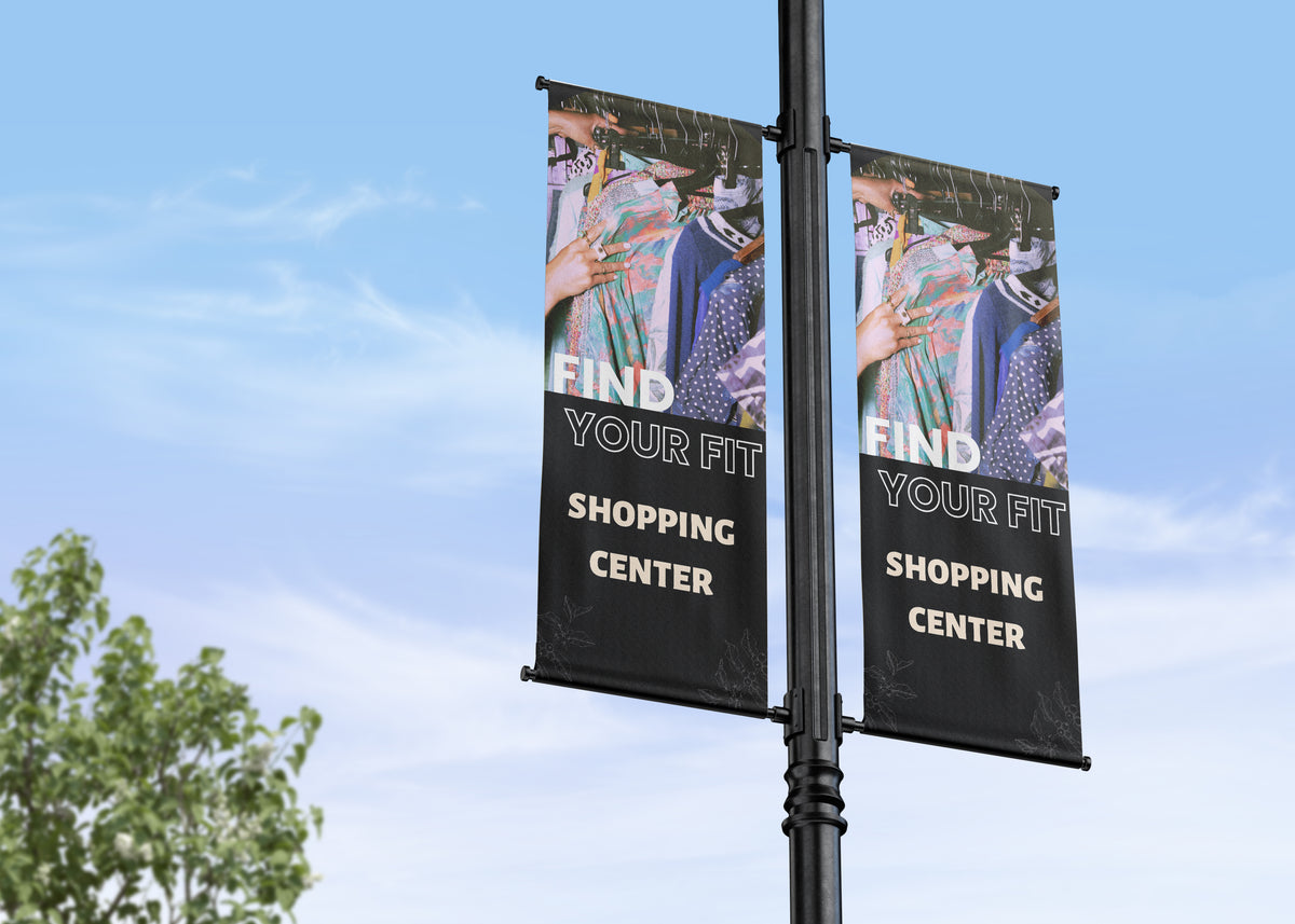 Two street banners on a pole with 'Find Your Fit Shopping Center' text against a blue sky.
